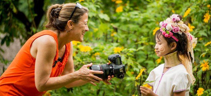 Woman photographer shows a girl her photo on the comaera montior during a 5 day photography workshop in Chiang Mai, Thailand