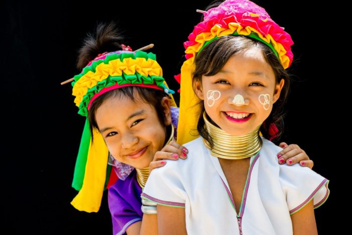 Two Kayan long neck girls photographed against a dark background during a Hill Tribe Traditions photography workshop.