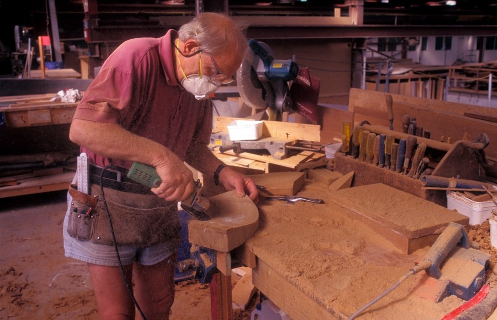 Man working with wood wearing a face mask